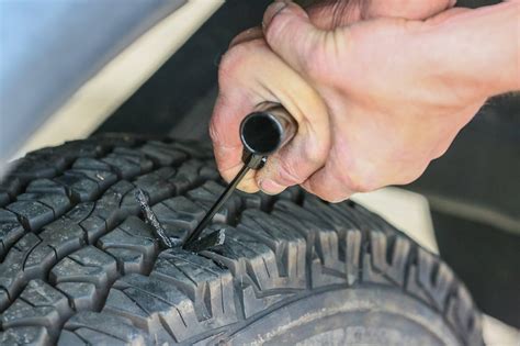 The driver or mechanic identifies the leak through visual inspection or using a soapy water spray. Remove debris from the hole and roughen the edges to increase adhesion. Insert the plug into the hole but then pull it out a bit to expose both ends. Cut these ends until the rest of the plug is flush with the tire surface.